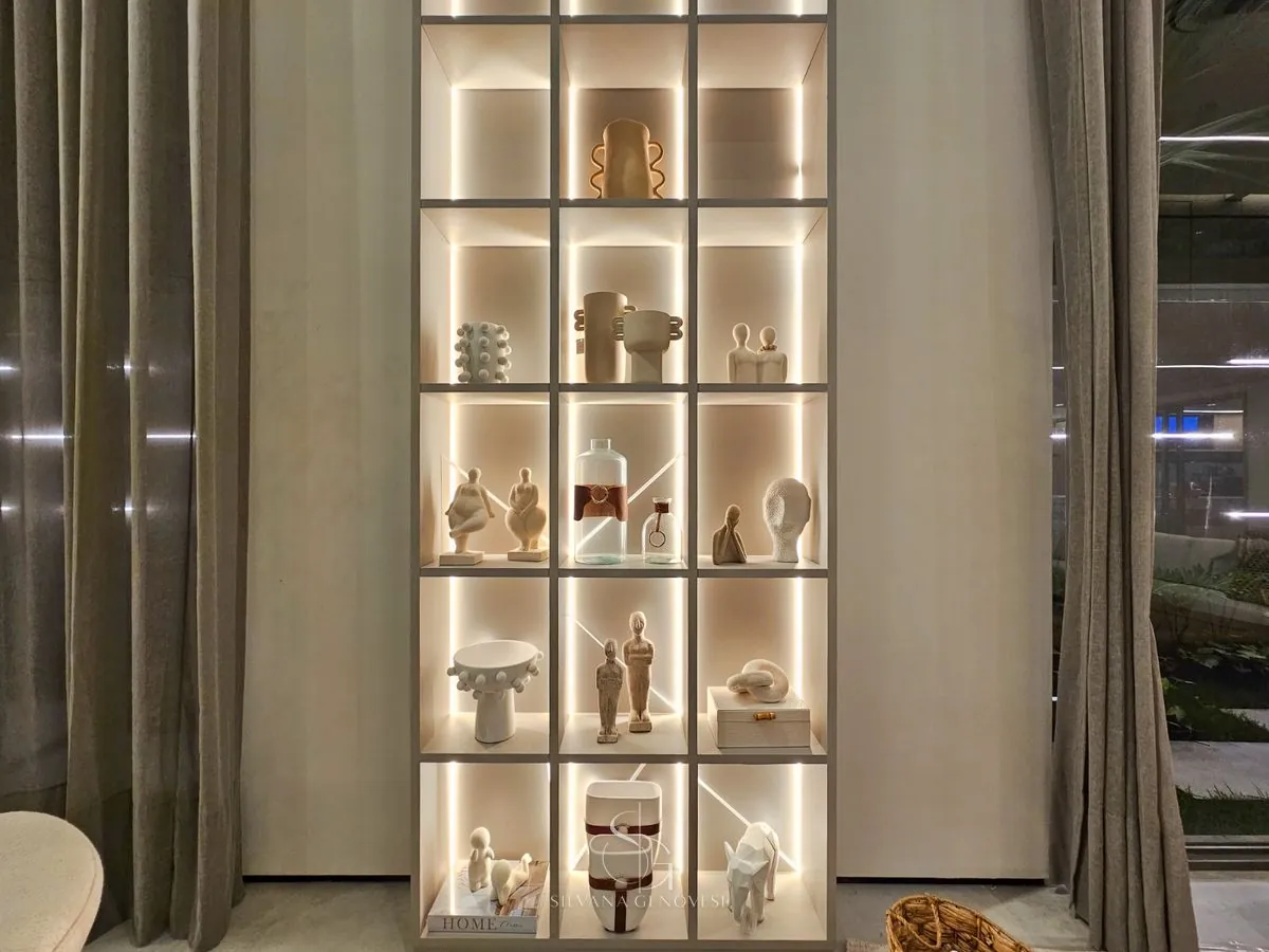 Estante de marcenaria com iluminação embutida e peças de cerâmica